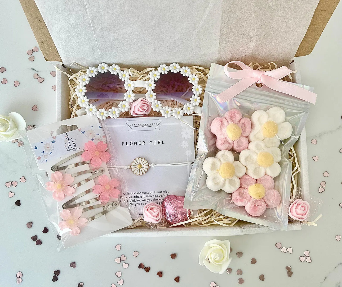 Gift set with flower-themed accessories including sunglasses, hair clips, and candies in a decorative box.