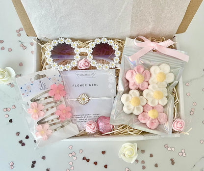 Gift set with flower-themed accessories including sunglasses, hair clips, and candies in a decorative box.